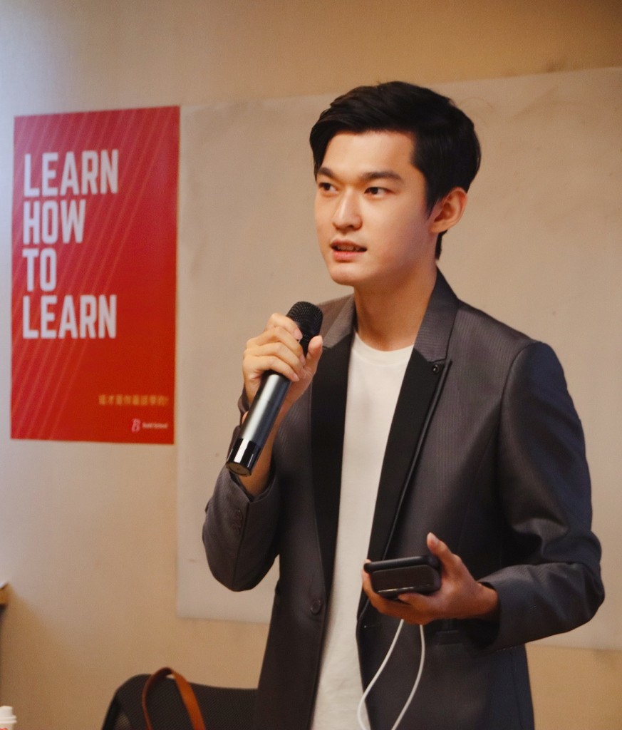 紹庸手持麥克風分享，身旁海報寫著 LEARN HOW TO LEARN